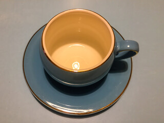 Empty coffee cup with saucer on a gray background