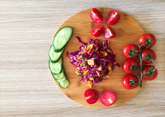 Salad and cherry tomatoes on a wooden board, view from above