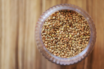 Lentils inside a bowl on a wooden table. View from above.