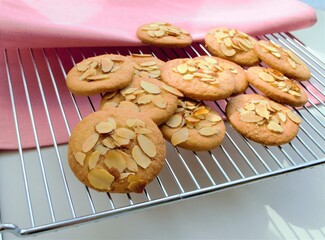 homemade cookies with almonds on an iron grill and a pink linen slice
