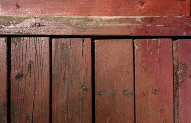 Old red wooden planks with cracks and crevices on the floor