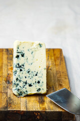Wedge of blue cheese on a cutting board