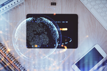 Double exposure of map hologram drawing over desktop. Top view. International connection concept.