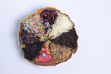 Terang Bulan or sweet martabak is a street food in Indonesia with the basic ingredients of flour and sugar. full color snacks isolated white background