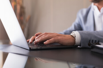 Male hands typing on the laptop