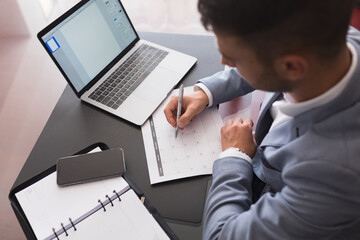 Young business man writing on a calendar