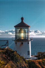 Fototapeta na wymiar Lighthouse on cliff with clouds at sunrise summer time