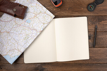 Travel planning concept. Traveler accessories. Gps navigator with blank notepad, map and compass on...
