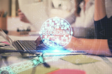 Double exposure of woman hands typing on computer and crypto market theme hologram drawing. Blockchain concept.