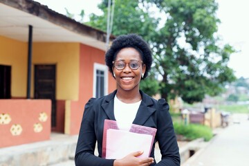 young beautiful african business lady holding a file and looking at the camera
