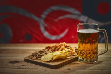 A glass of beer and different snacks on the table. Celebrating international beer day or Octoberfest. Drinking beer after a hard working day or week