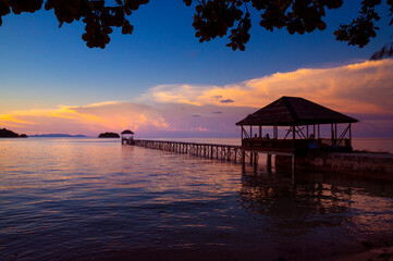 Obraz premium beach with walkway to the sea at sunset
