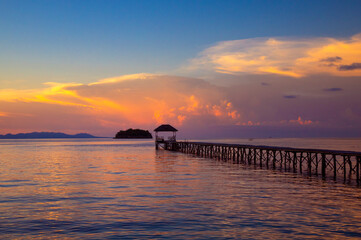 Naklejka premium beach with walkway to the sea at sunset