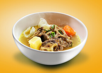 Oxtail soup. Ribs are cooked with broth plus potatoes, carrots and cabbage. Hot oxtail soup served in a ceramic bowl.