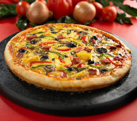 Pizza on wooden plate. Bread topped with sausages, smoked meats, mushrooms, green peppers, red peppers, pineapple, cheese, mozarela.