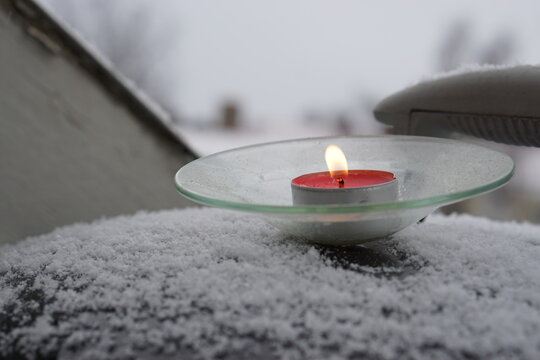 The Red Candle On The Snow Out Side The House