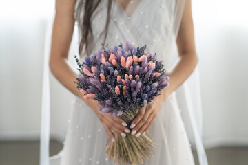 the bride holds in her hand a bouquet of dried flowers, eco wedding