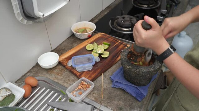 Woman use motar to prepare making food.