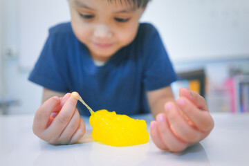little boy playing with yellow elastic toy