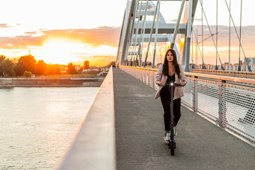 A young girl riding her electric scooter on the bridge © MexChriss