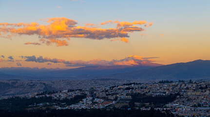 Impressive landscape of the Cayambe volcano at sunset with the skyline of Quito city, Ecuador.