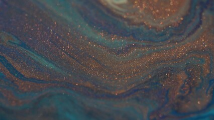 Metallic bronze and blue. Liquid glittery paint texture. Acrylic. Chemical reaction. Fantastic patterns and shapes