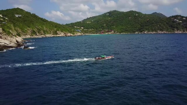 Drone flies over the longtail boat close to the coast. Koh Tao. Thailand