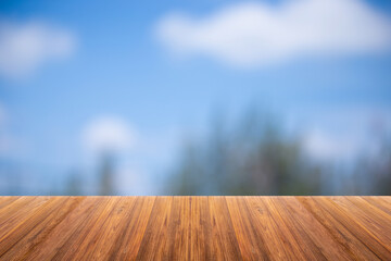 Wooden board on Blurry trees and blue sky
