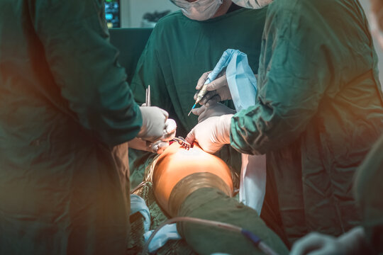 hip replacement surgery in progress, open cavity with scalpel and soft-tissue retractors. Orthopedic surgeons in teamwork in the operating room with modern arthroscopic tools. Hospital background