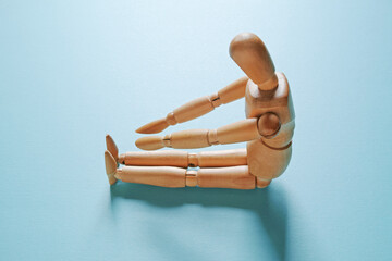 青背景で長座体前屈をしている木製のモデル人形【側面　ハイアングル】