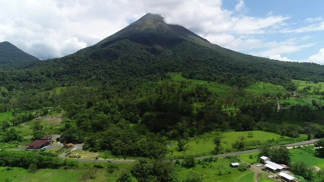 Volcan in Central America and nearby road and houses aerial shot