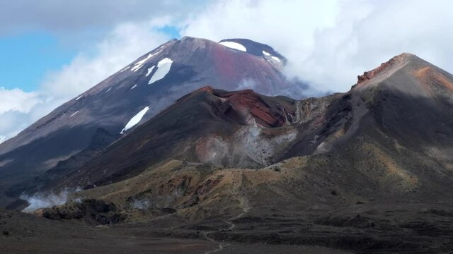 Path leads up a dramatic red volcano mount doom with slowly moving clouds