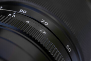 Detail of a camera lens for photography or video. Black with white letters and numbers