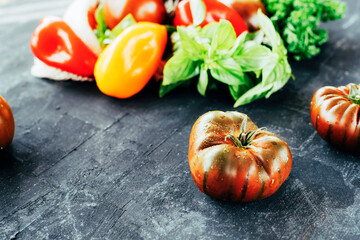 Bio organic vegetables on black chalkboard background, healthy raw vegan food concept. Selective focus