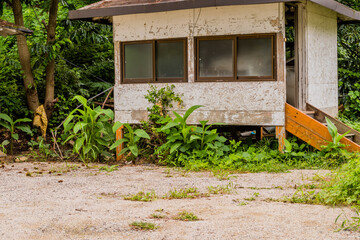 Fototapeta na wymiar Abandoned cabin with gravel parking
