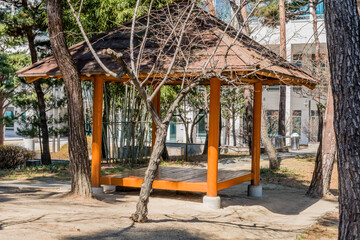 Fototapeta na wymiar Wooden picnic shelter in public park.