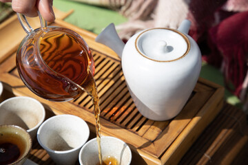 Tea ceremony at the outdoors camping site. Pouring some tea