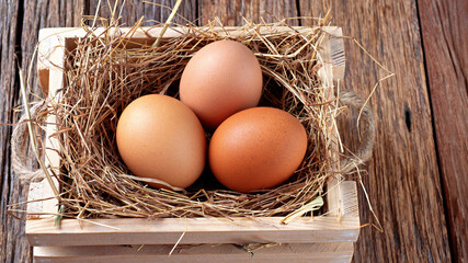 fresh eggs on wooden box with straw