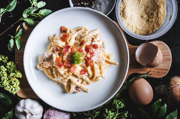 Pasta Carbonara in white dish, surround fresh ingredients