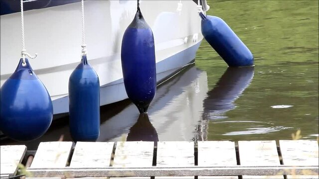 blue fender, boat at a wooden pier 
 