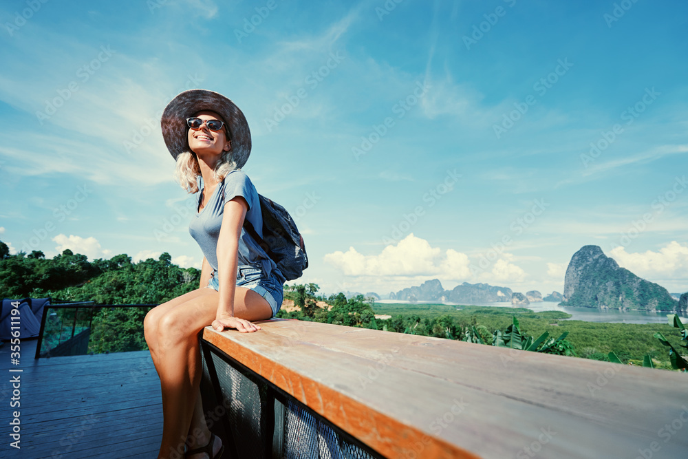 Wall mural traveling by thailand. young tourist woman enjoying wonderful view of phang nga bay with rock island