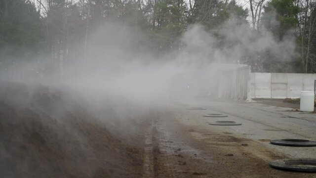 Steam billowing off a freshly churned manure pile