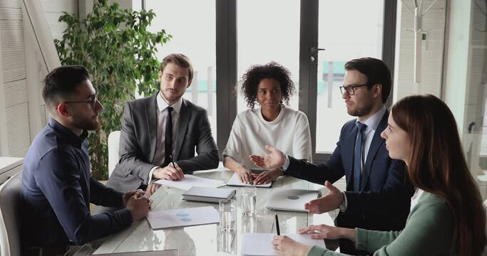 Smiling caucasian and arab business partners handshake at group office meeting. Diverse executive manager and client investor shake hands celebrate marketing growth, team partnership agreement deal.