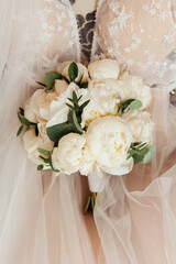 luxurious bouquet in the hands of the bride in a wedding dress and veil, rings
	
