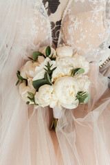 luxurious bouquet in the hands of the bride in a wedding dress and veil, rings
	
