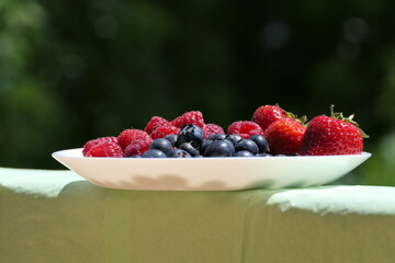 Dessert plate with fresh, healthy, brightly coloured berries is ready: blueberries, raspberries, strawberries