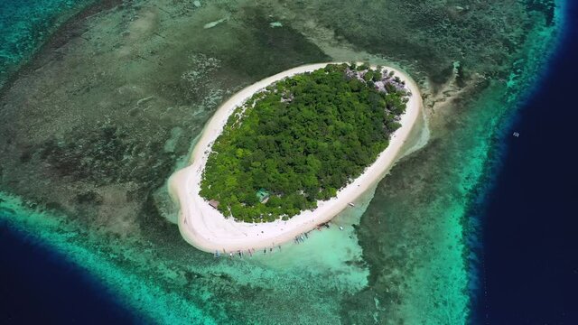 Tropical Mantigue Island in the Philippines, overhead backwards aerial