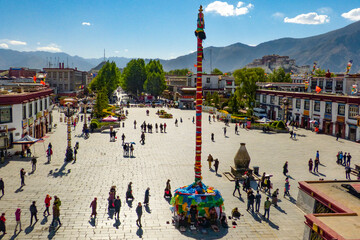 A large prayer pole adorned with prayer flags standing tall at the Jokhang square in Lhasa, Tibet