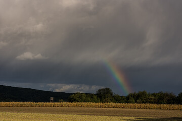 short rainbow with rain clouds during a thunderstorm