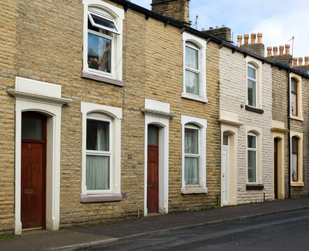 Urban terrace. Typical scene of a row of terraced houses in warm yellow stone, in a Lancashire mill town, England.